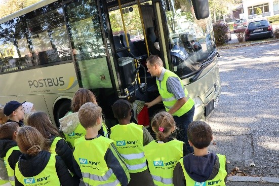 Schulkasse mit Warnwesten an steigen in einen Bus